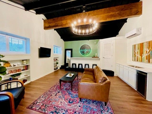 A living room with a couch , chair , table and television.