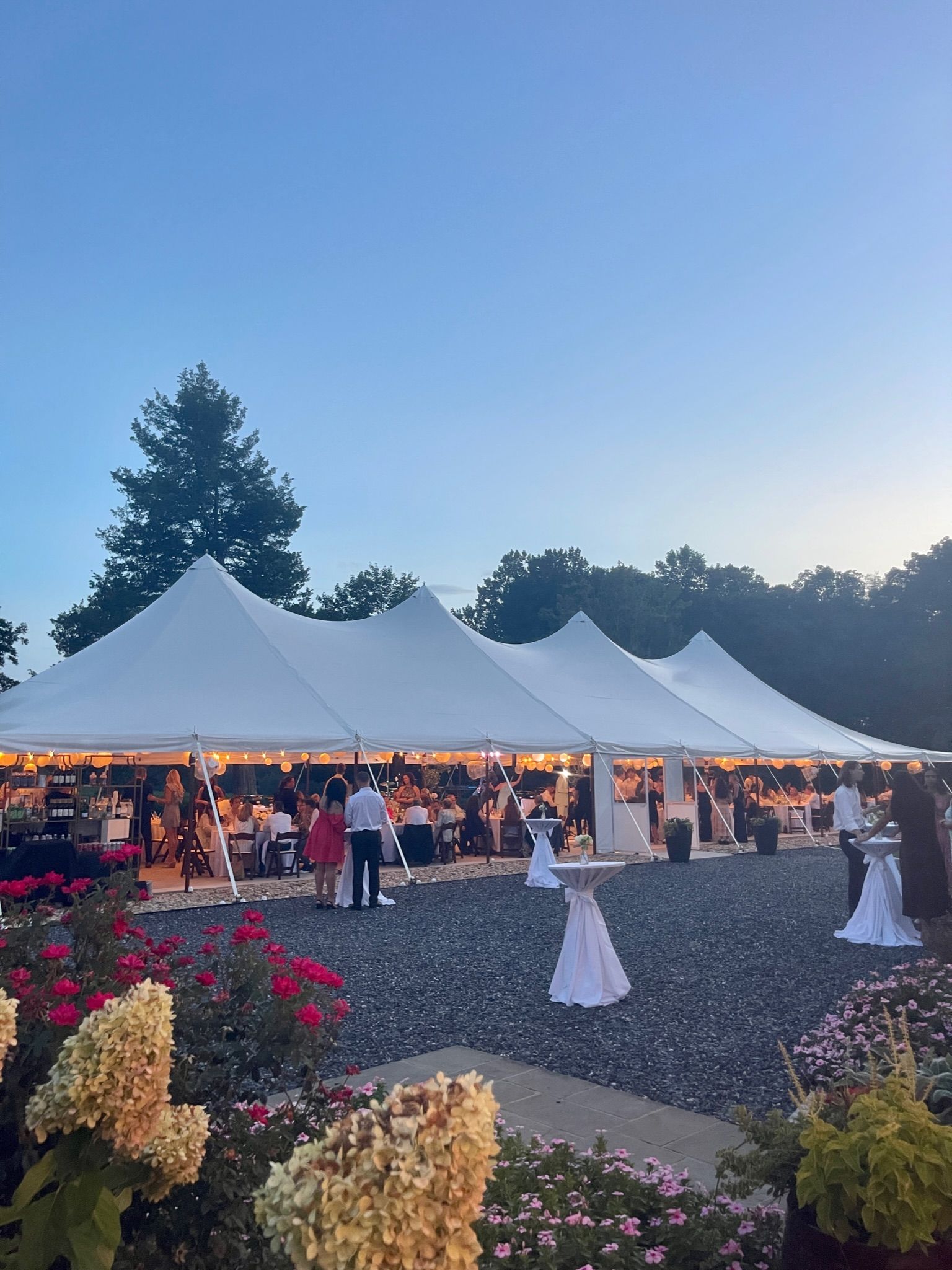 A large white tent is being used for a wedding reception.