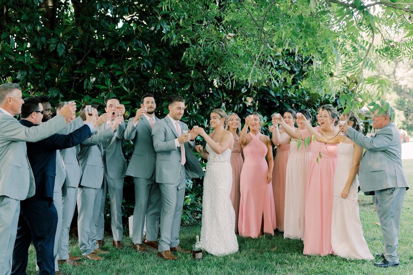 A bride and groom are posing for a picture with their wedding party.