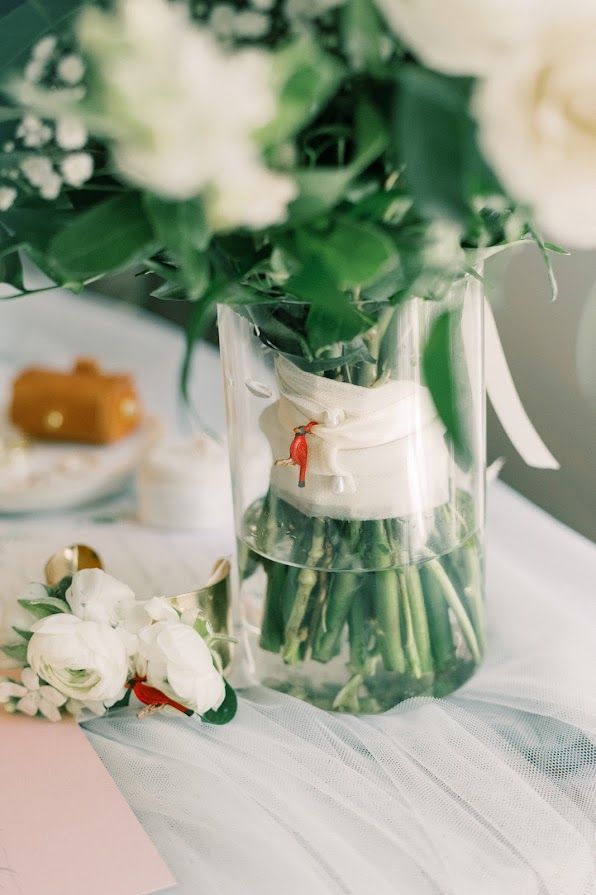 A vase filled with water and flowers is sitting on a table.