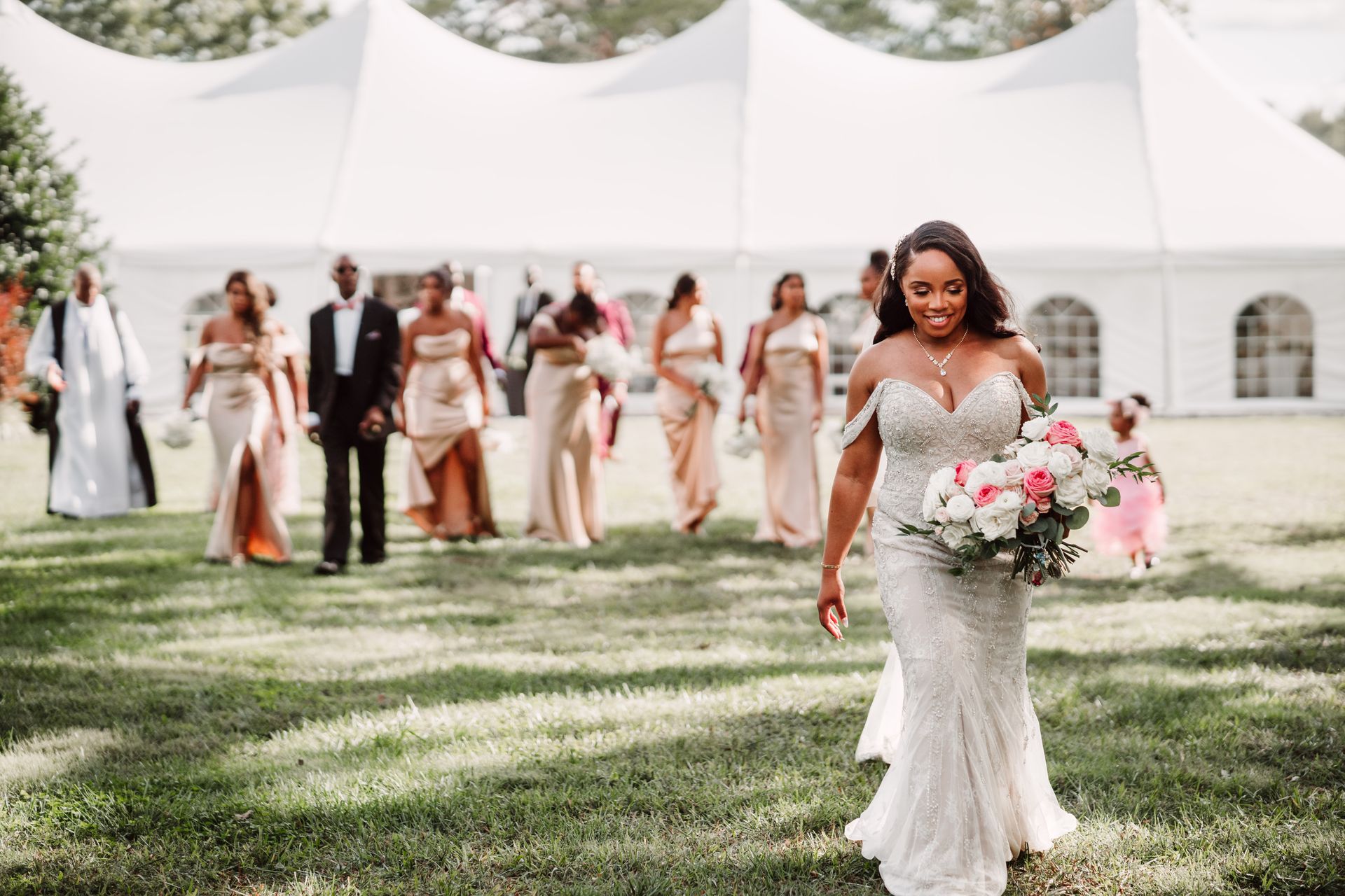 A bride is walking down the aisle with her wedding party.