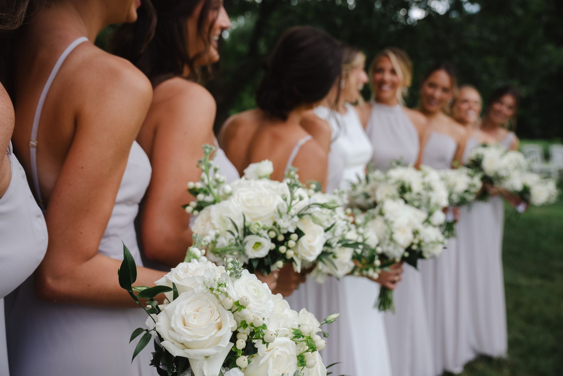 A bride and her bridesmaids are holding bouquets of white flowers.