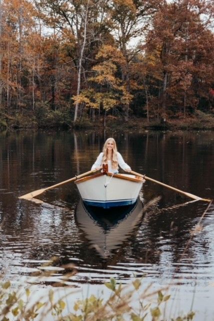 A woman is rowing a boat on a lake.
