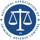National Association of Criminal Defense Lawyers logo: Scales of justice in white on a blue circle.
