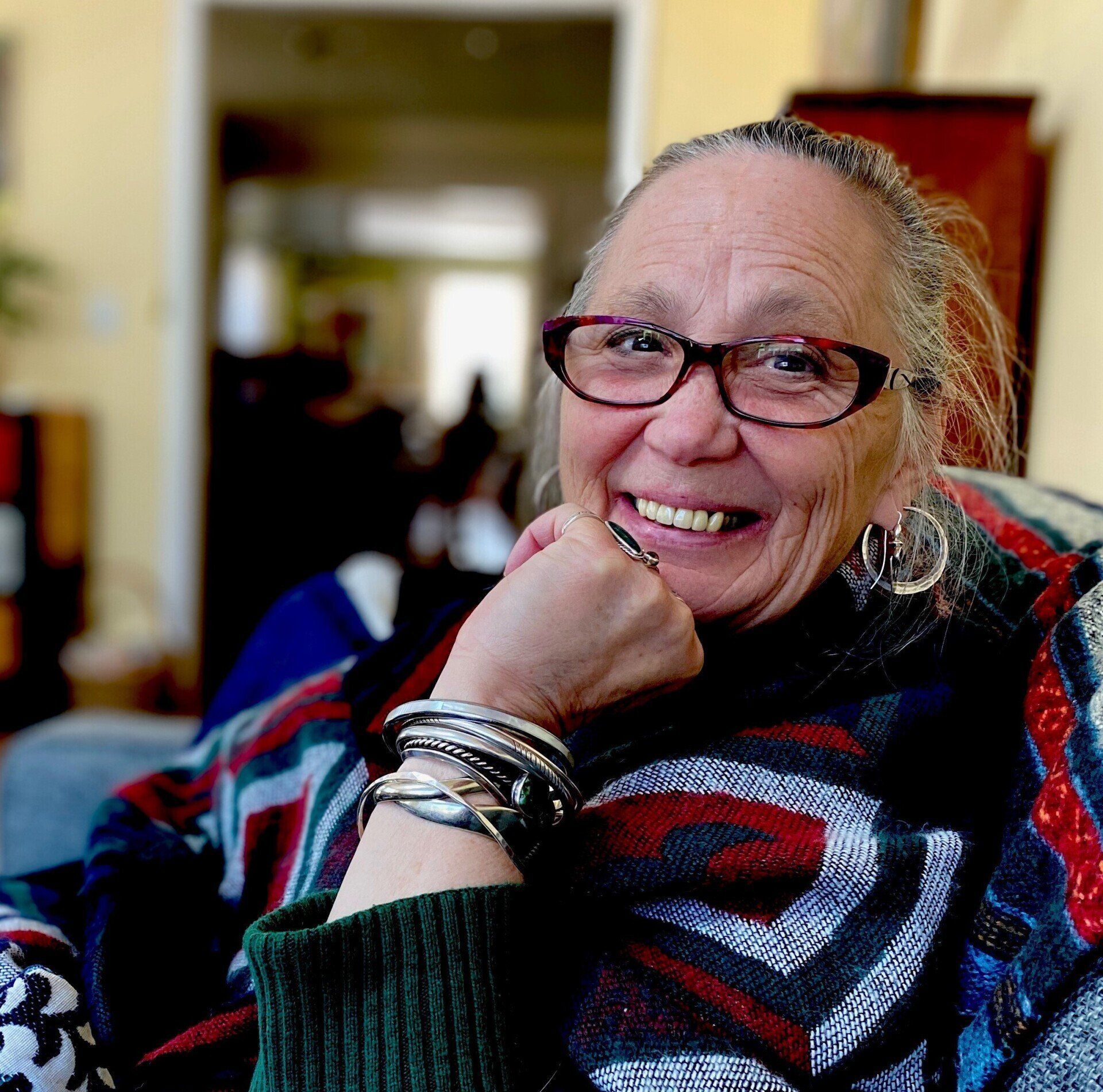 A man wearing glasses and a suit smiles for the camera