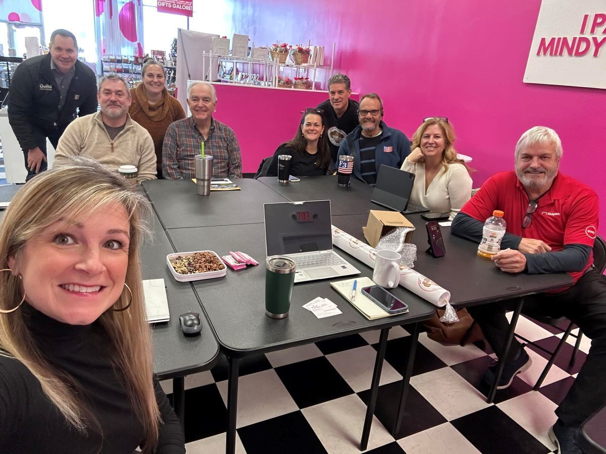 A man is giving a presentation to a group of people sitting around a table