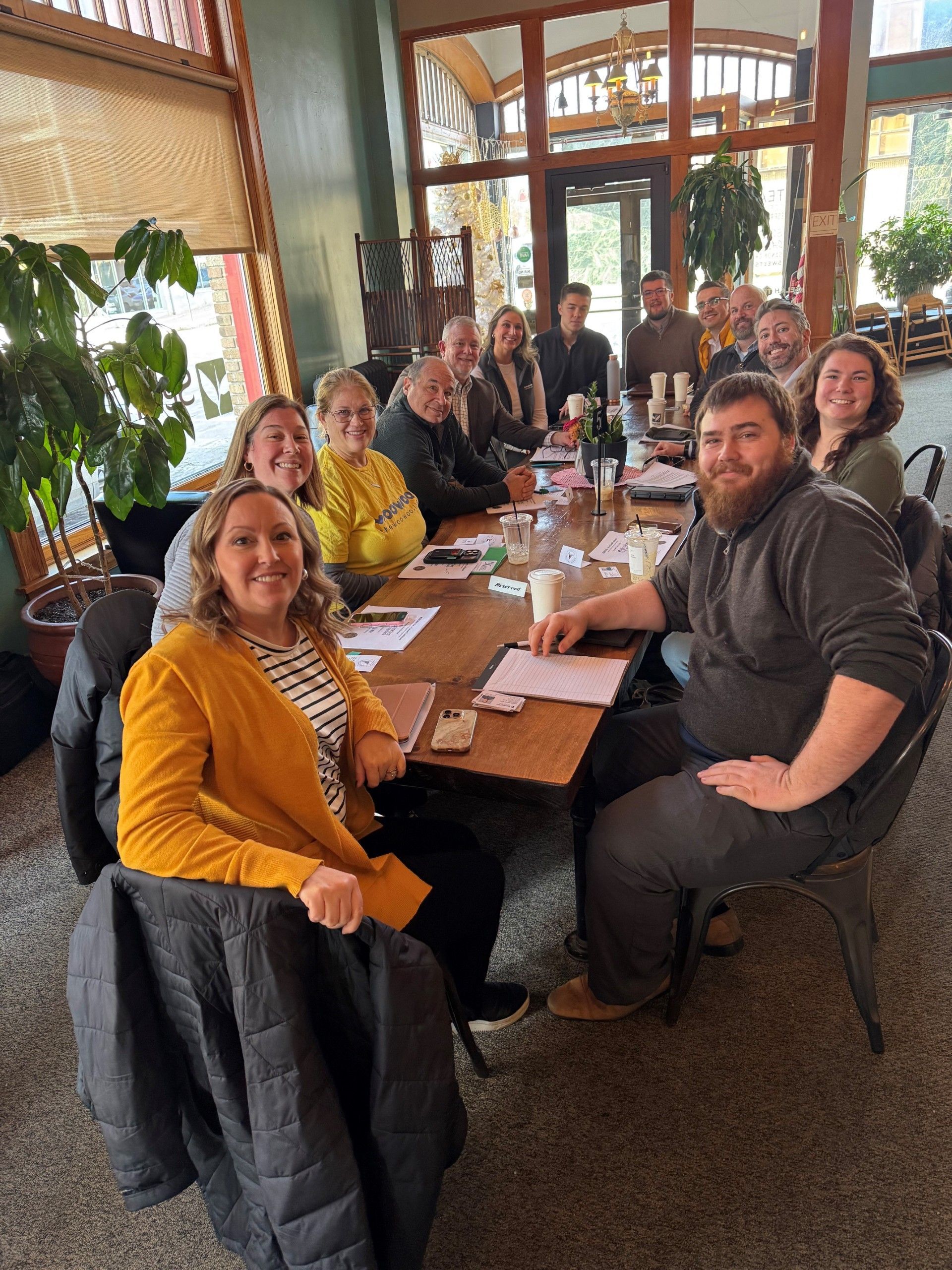A group of people are sitting around a table for the Portland TBD networking meeting.