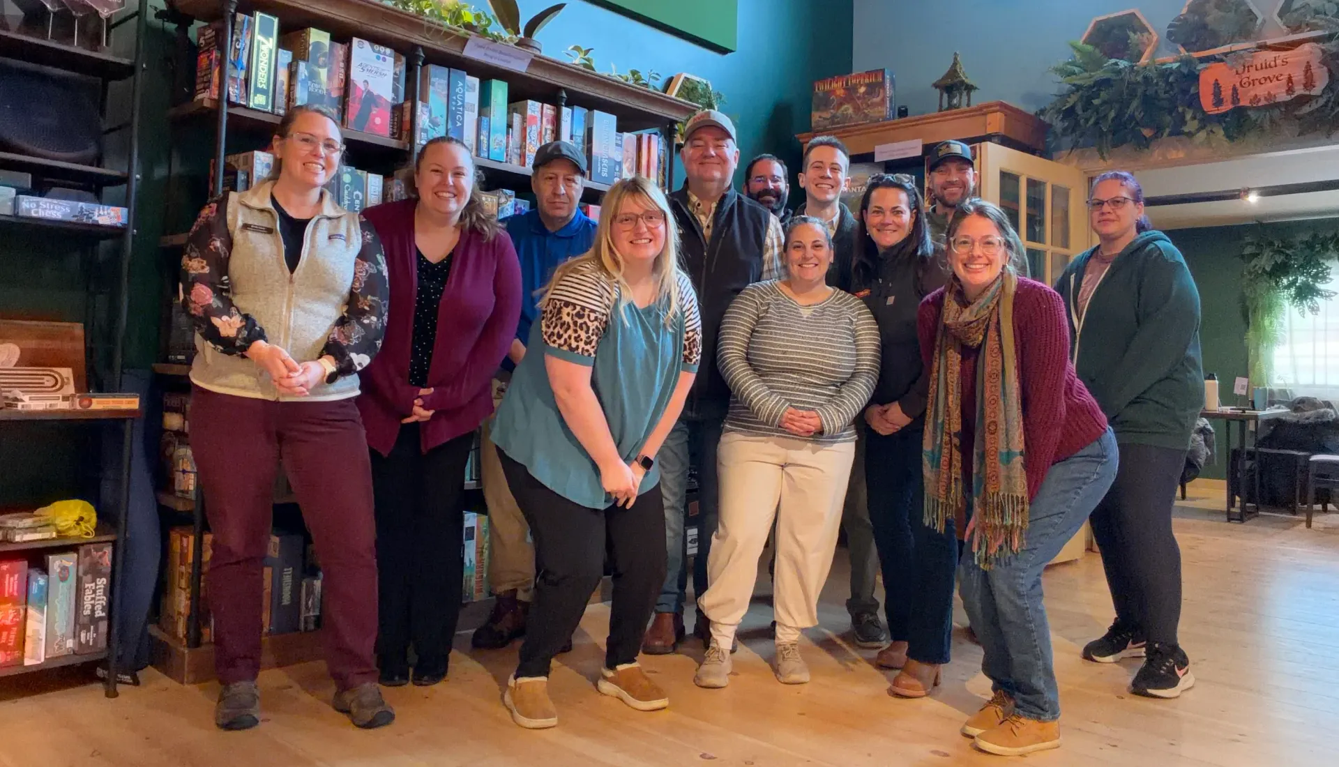 A group of people are sitting around a long wooden table.