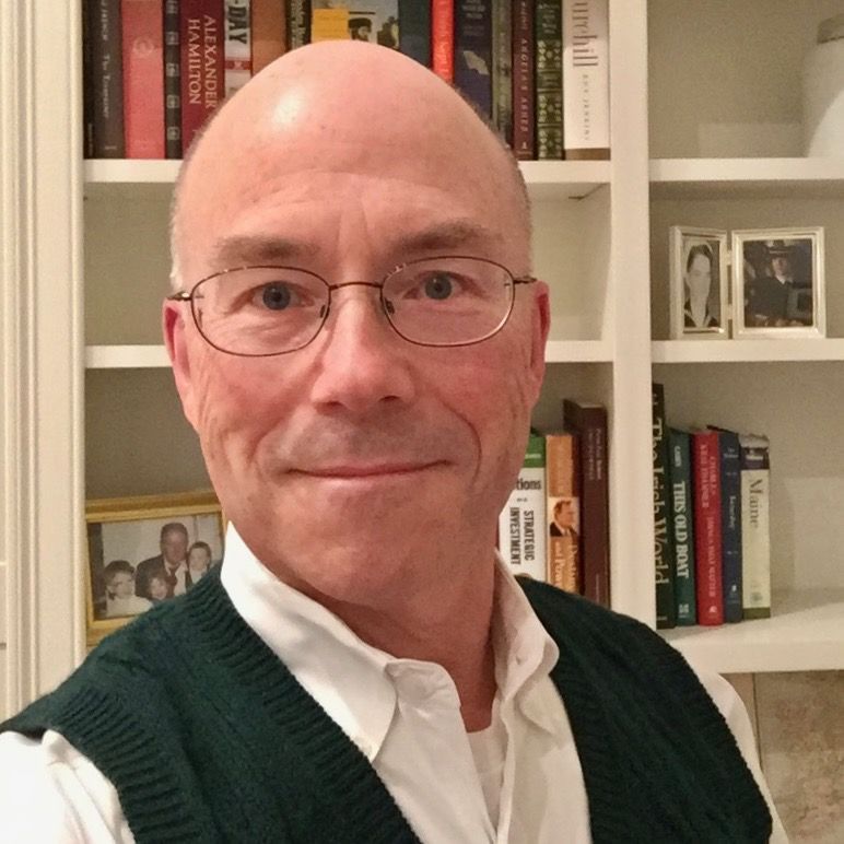 A man in a blue shirt is smiling for the camera