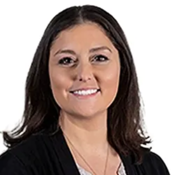 A young man with a beard is wearing a black shirt and smiling at the camera.