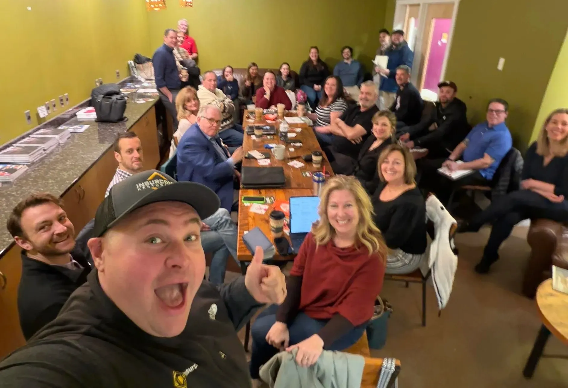 A group of people are sitting around a table for the Portland TBD networking meeting.