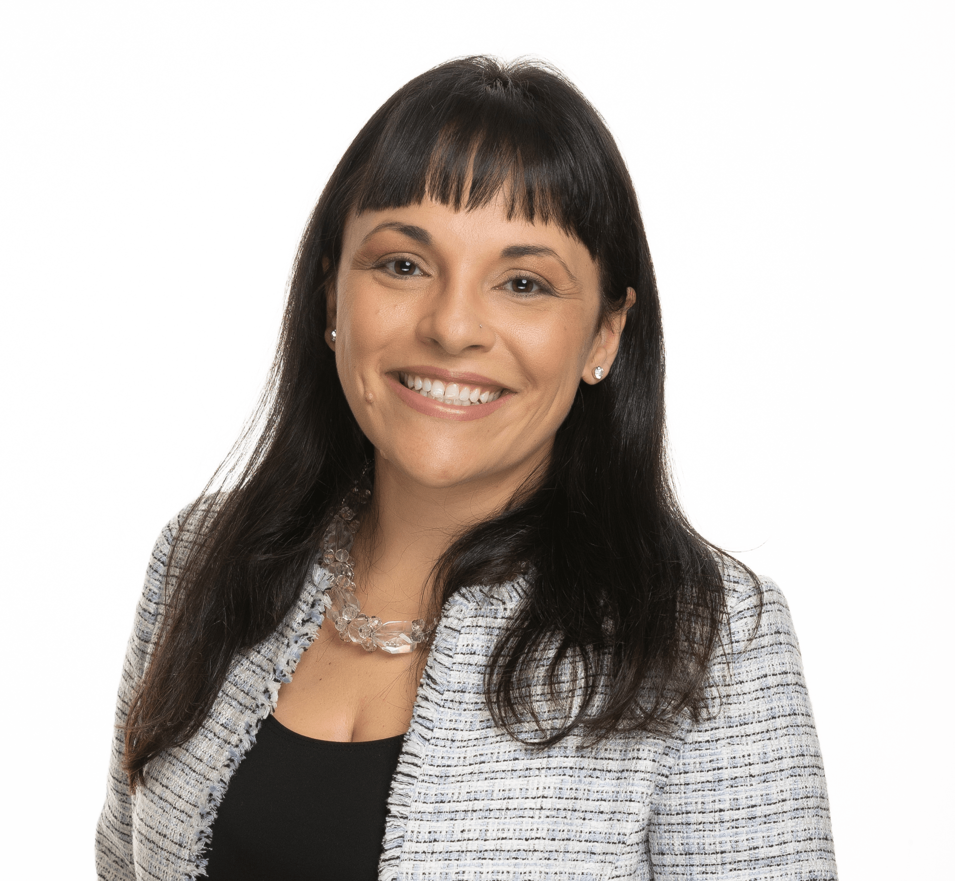 A woman wearing a black top and a gray jacket is smiling for the camera.
