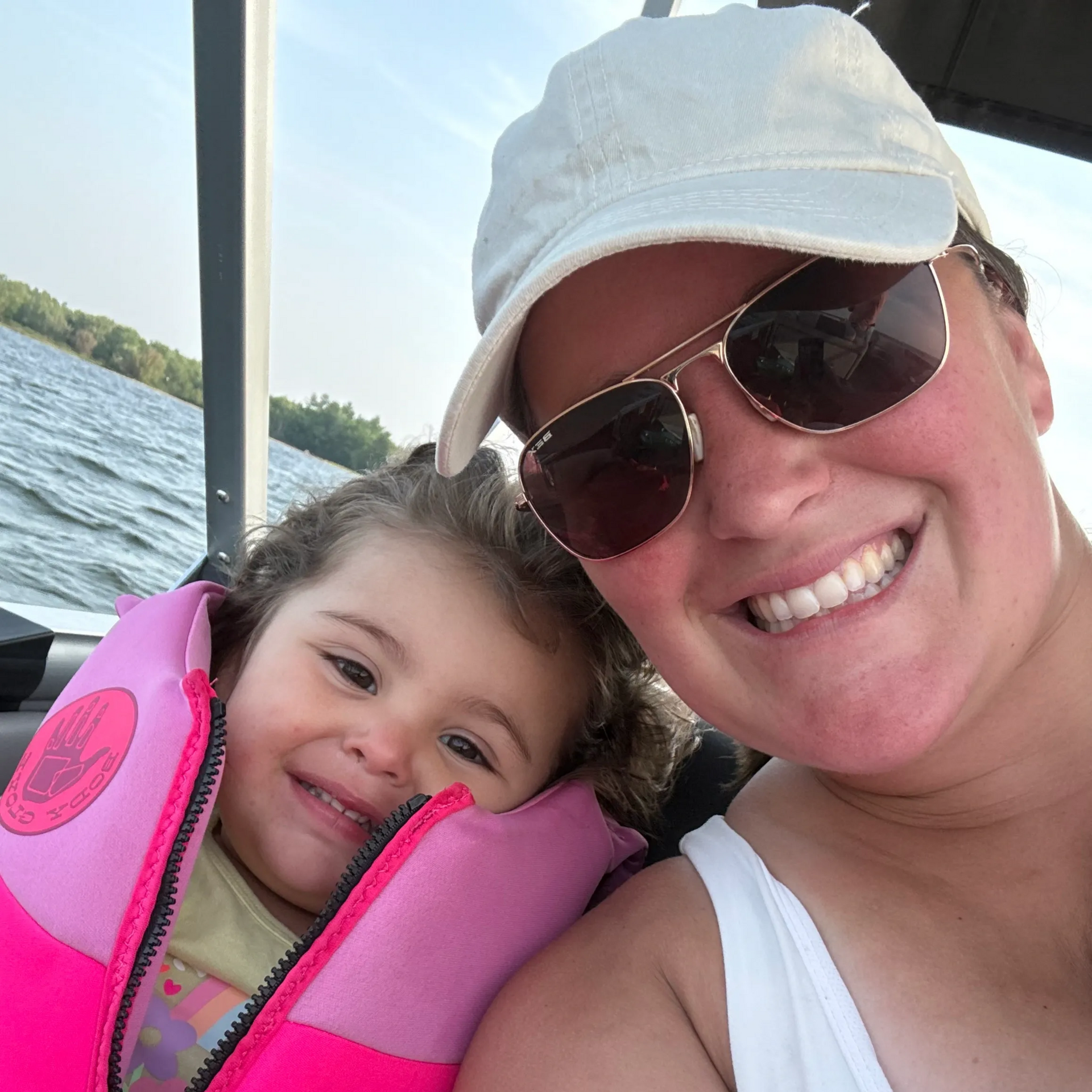 Man with short dark hair, goatee, and black tie smiles at the camera in front of a blurred outdoor backdrop.
