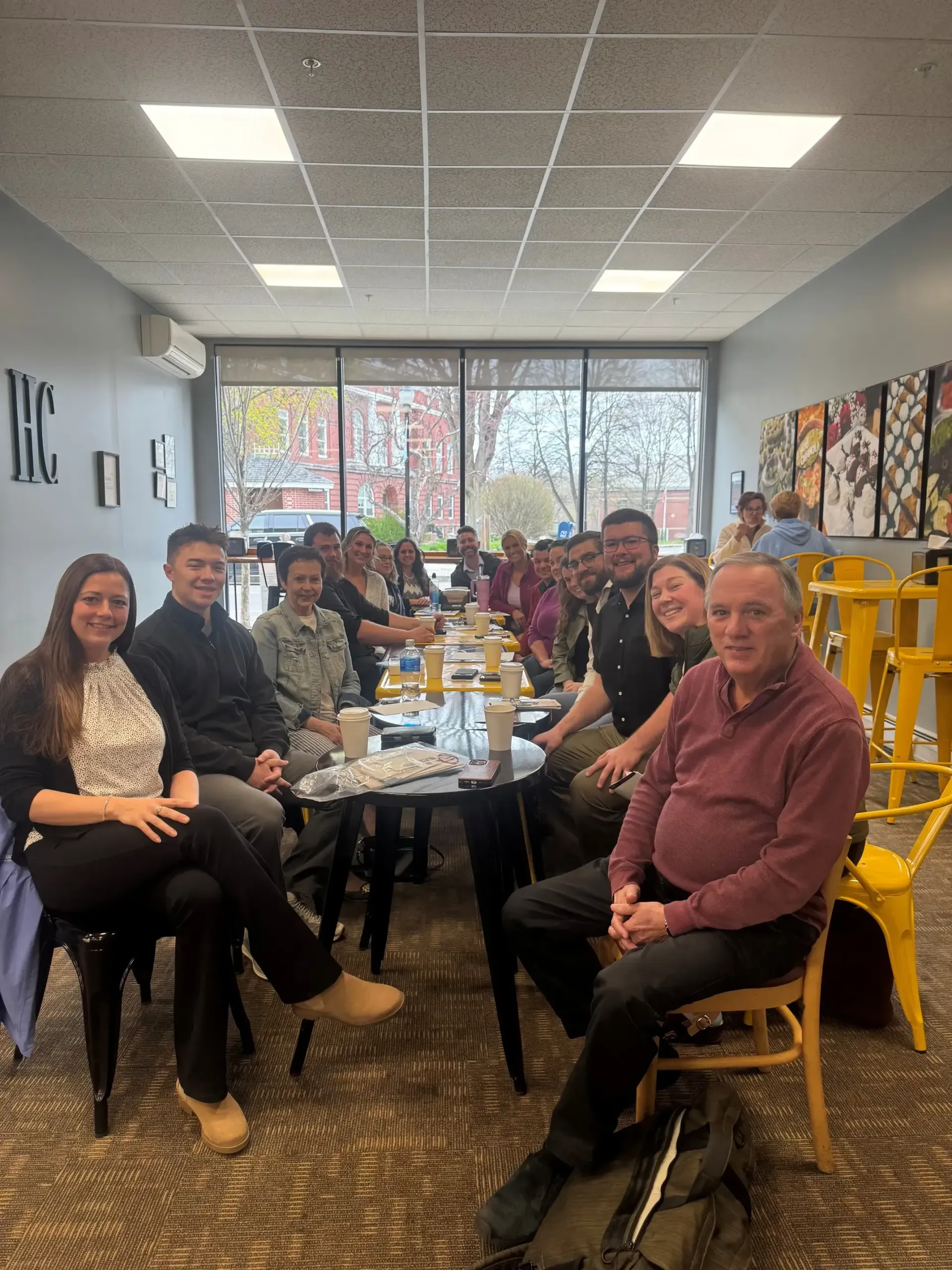 A group of people are sitting around a table for the Portland TBD networking meeting.
