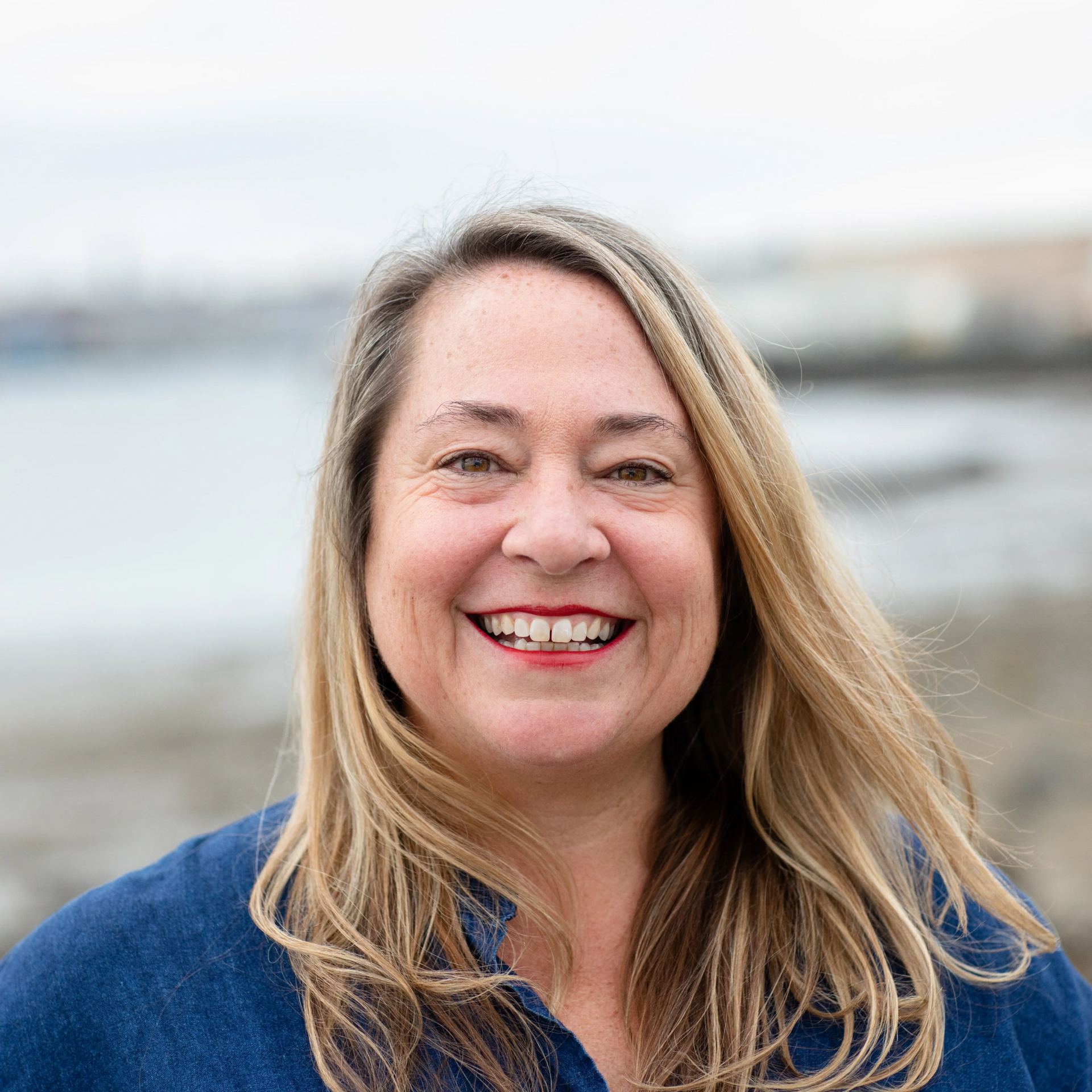 A woman stands in front of a sign that says ls
