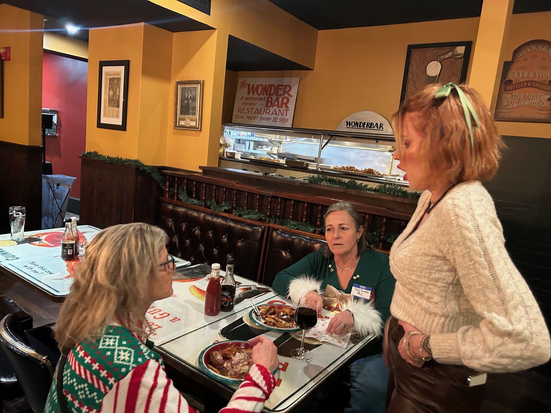 Three women are sitting at a table in a restaurant eating food.