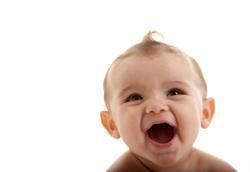 Smiling baby with open mouth, light skin, and small tuft of hair against white background.