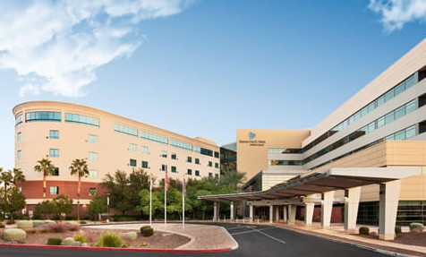 Hospital building exterior with a curving facade and covered entrance.