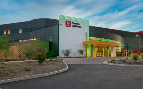 Phoenix Children's Hospital exterior with a white and green facade, curved modern design, and desert landscaping.
