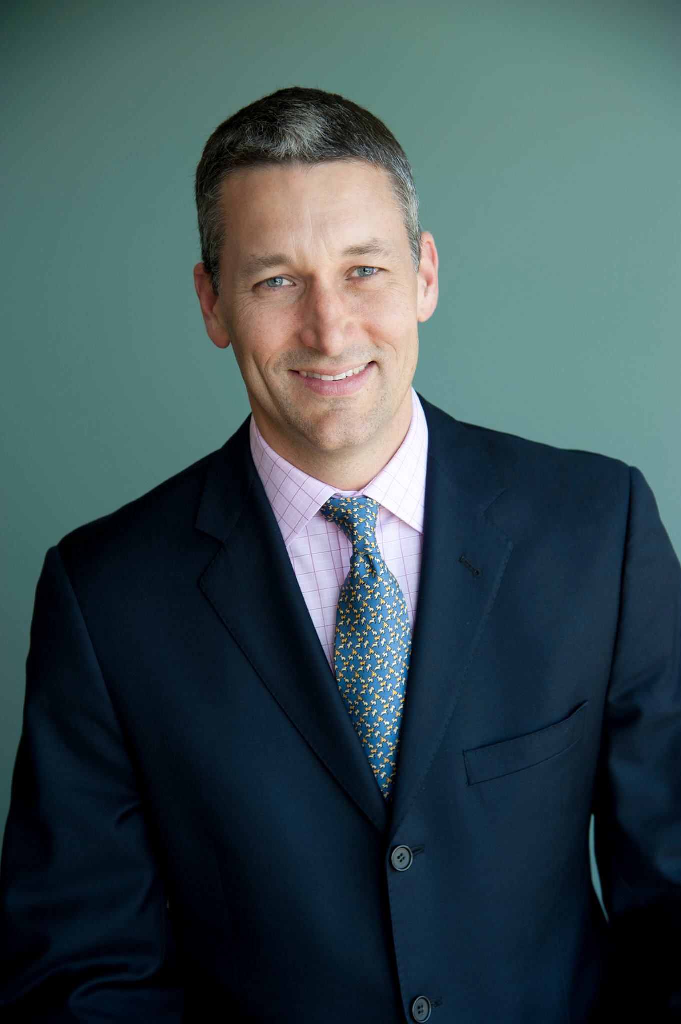 A man in a suit and tie is smiling for the camera.