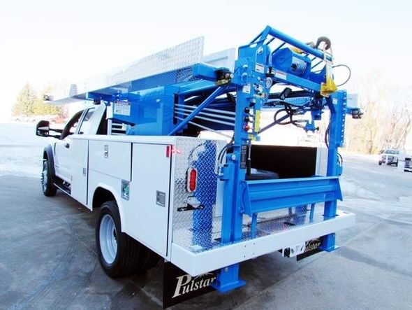 A white utility truck with well service equipment is parked, representing a licensed water well service company.