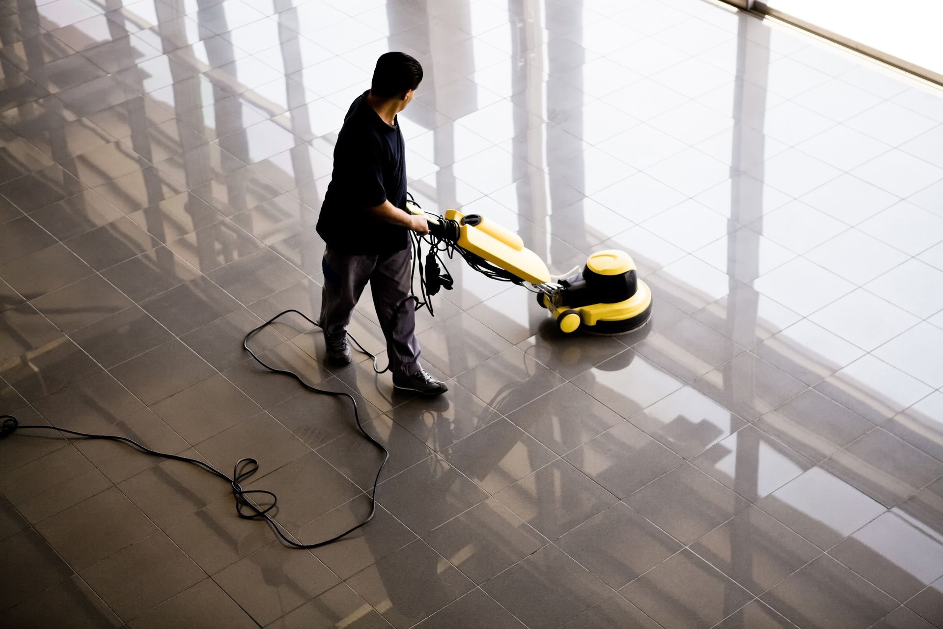 Professional tile and grout cleaning service using a high-powered vacuum for deep floor cleaning.