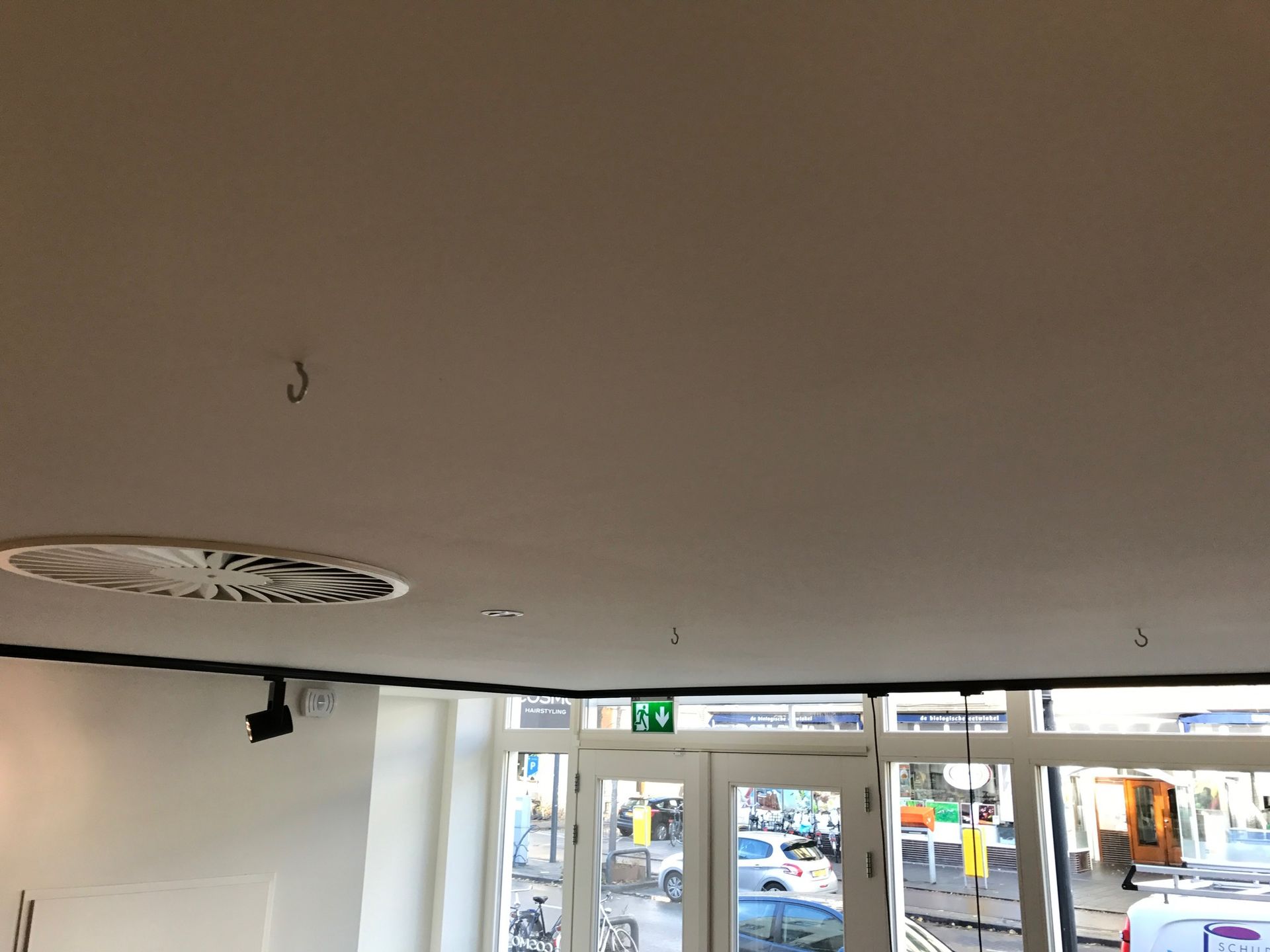 Interieur van de kamer in aanbouw; houten plafond en wandpanelen, ramen, ladder.