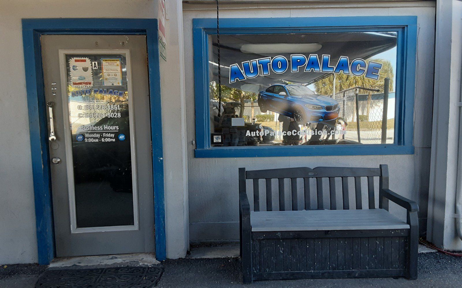 A bench is in front of a car dealership called auto palace