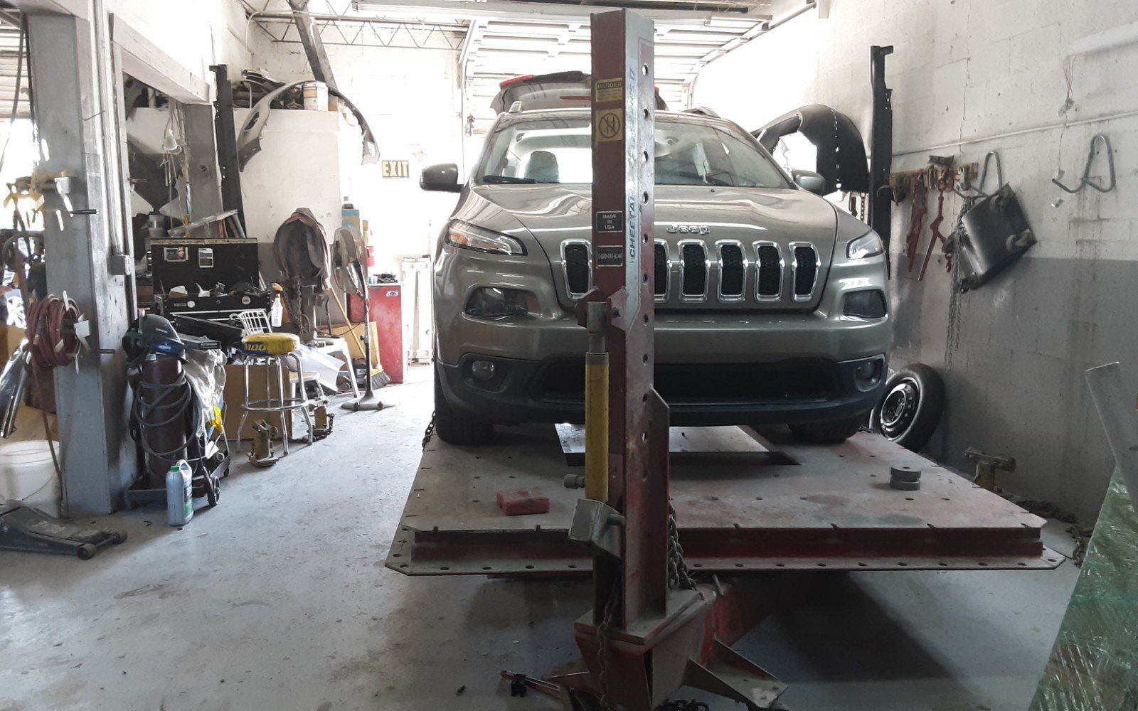 A jeep is parked on a lift in a garage
