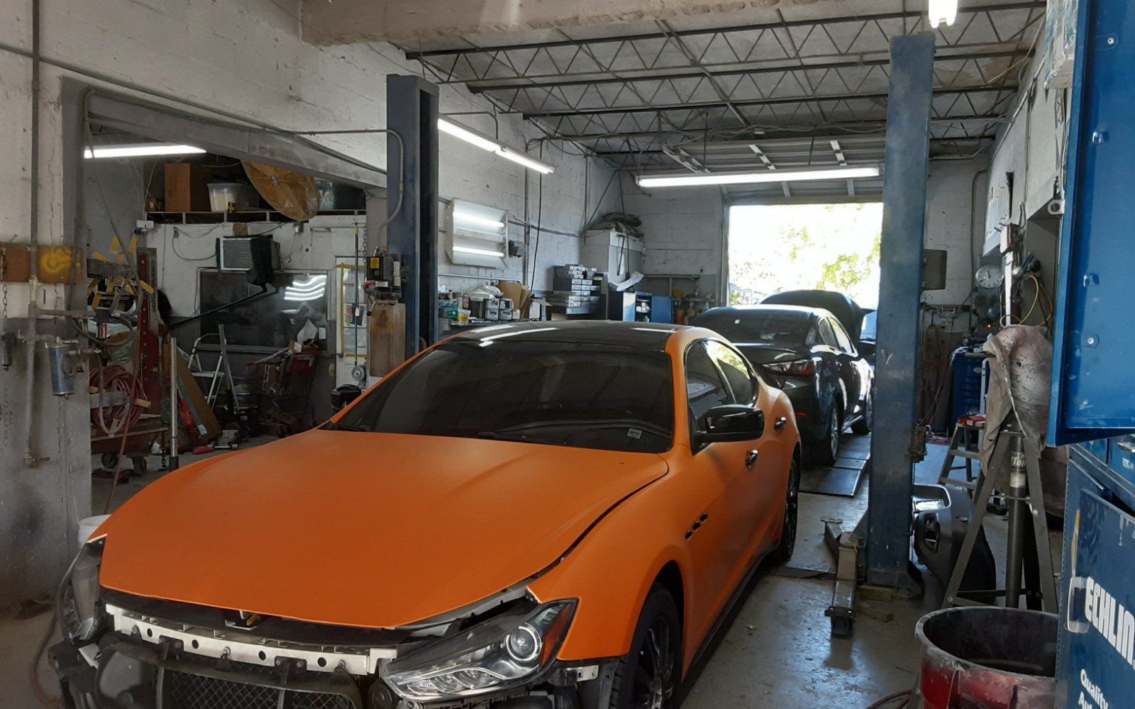 A car is sitting on a lift in a garage.