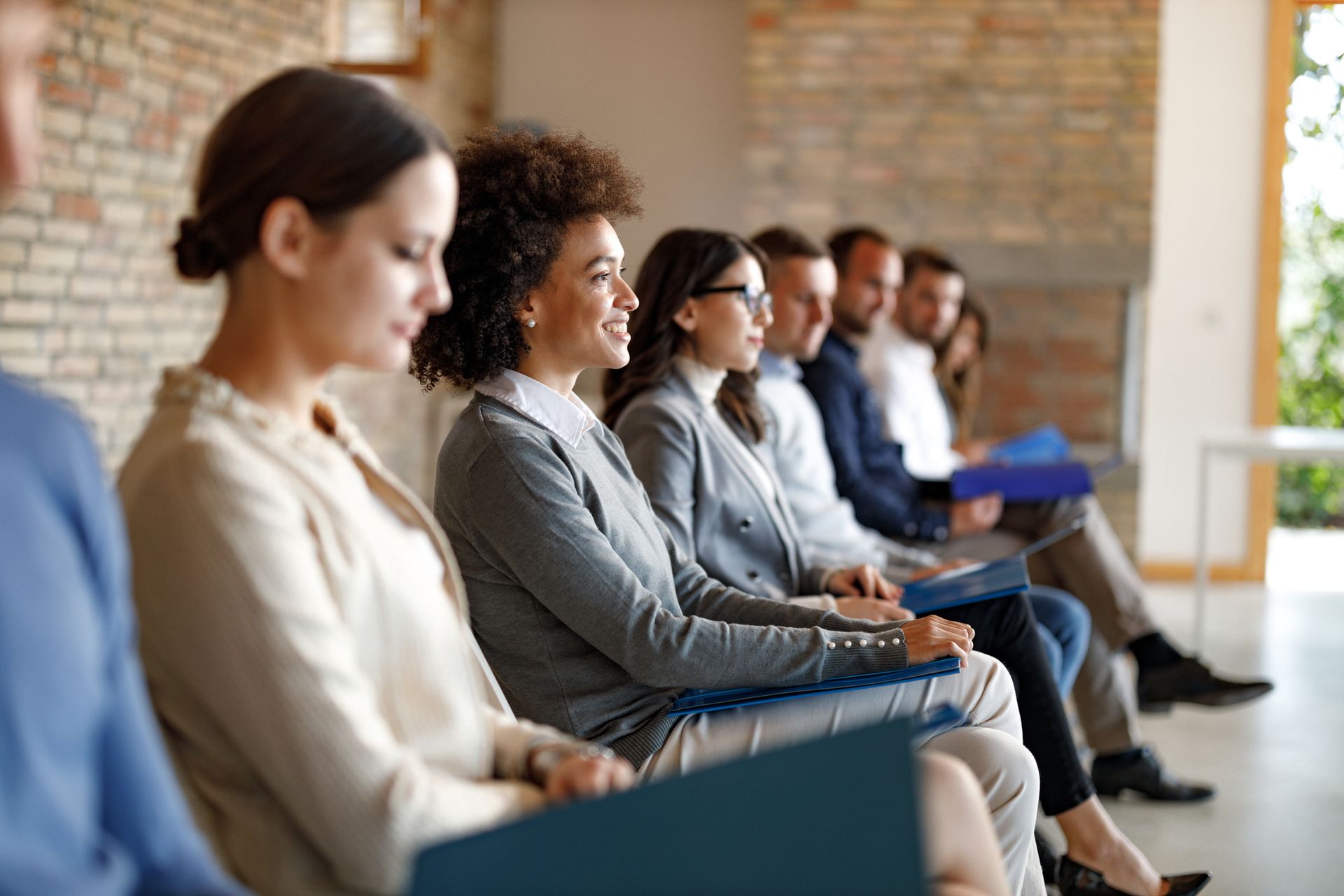 A group of people are sitting in a row at a job interview.