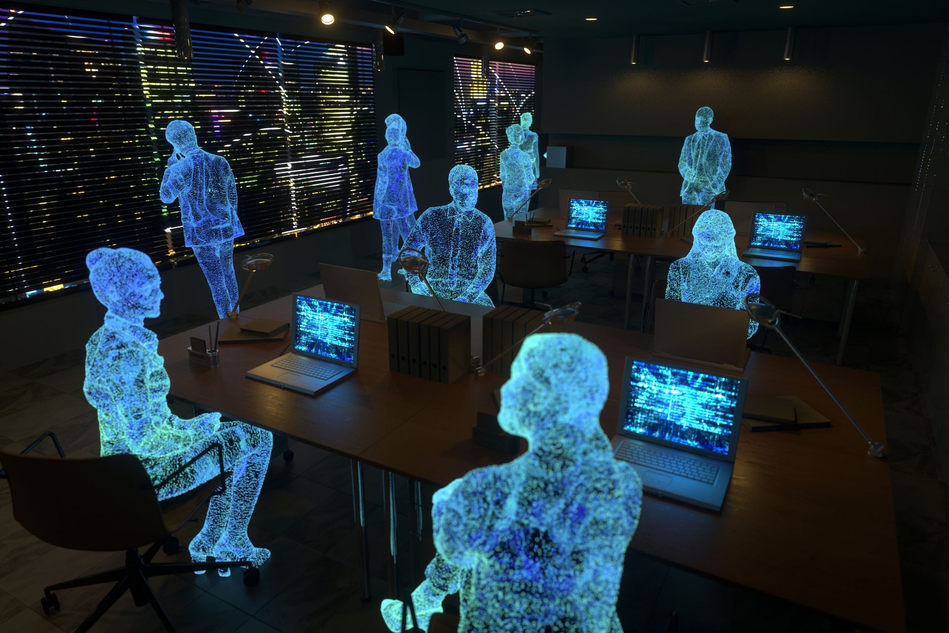 A group of people are sitting around a table with laptops.