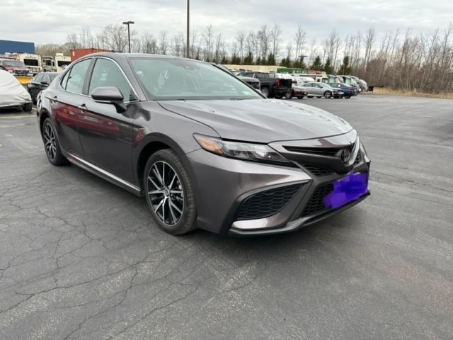 A gray toyota camry is parked in a parking lot.