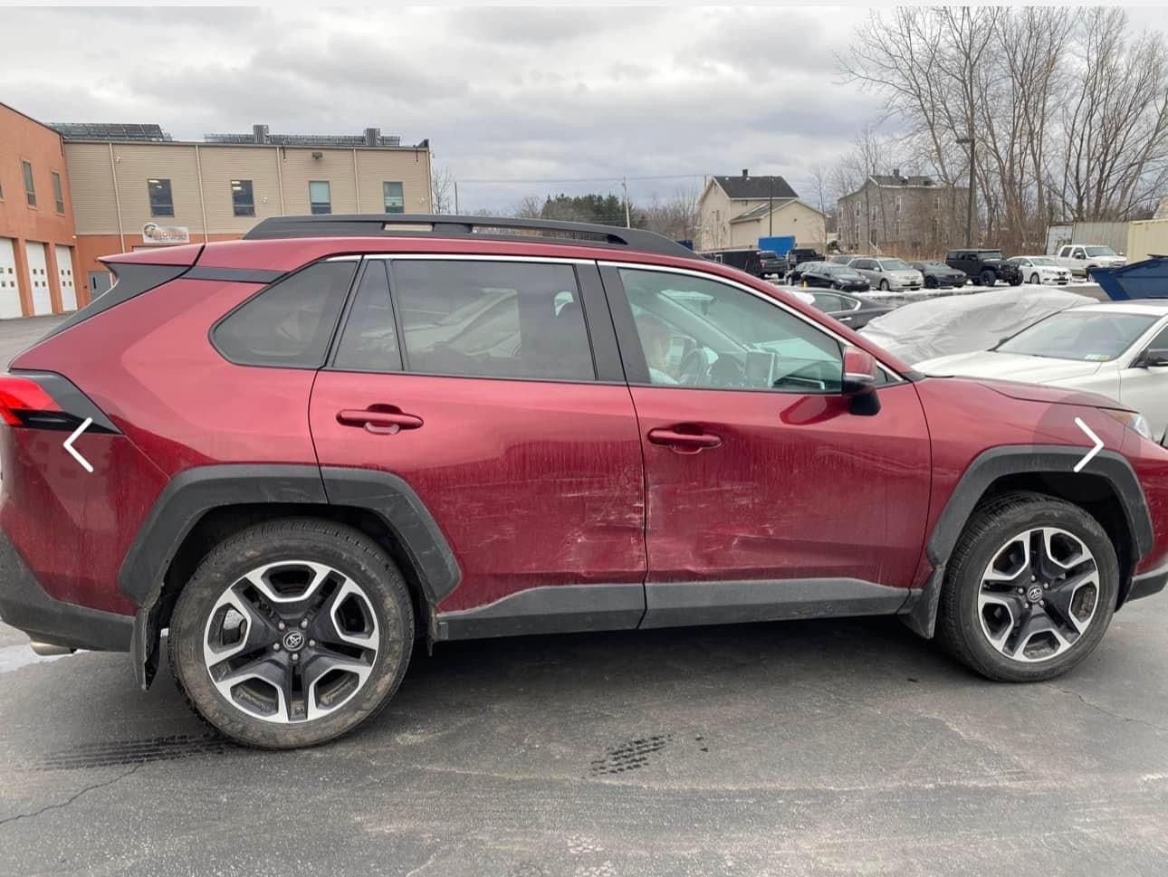 A red toyota rav4 is parked in a parking lot.