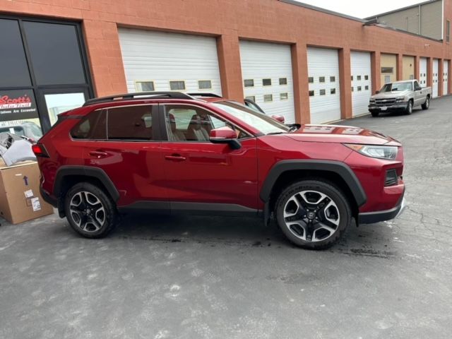A red suv is parked in front of a building