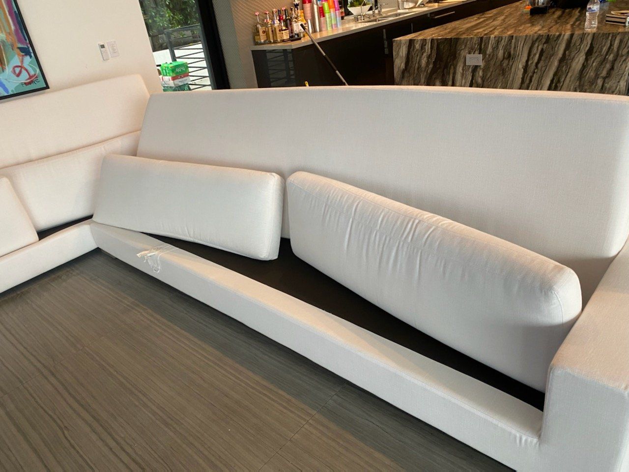 A white couch is sitting in a living room next to a bar.