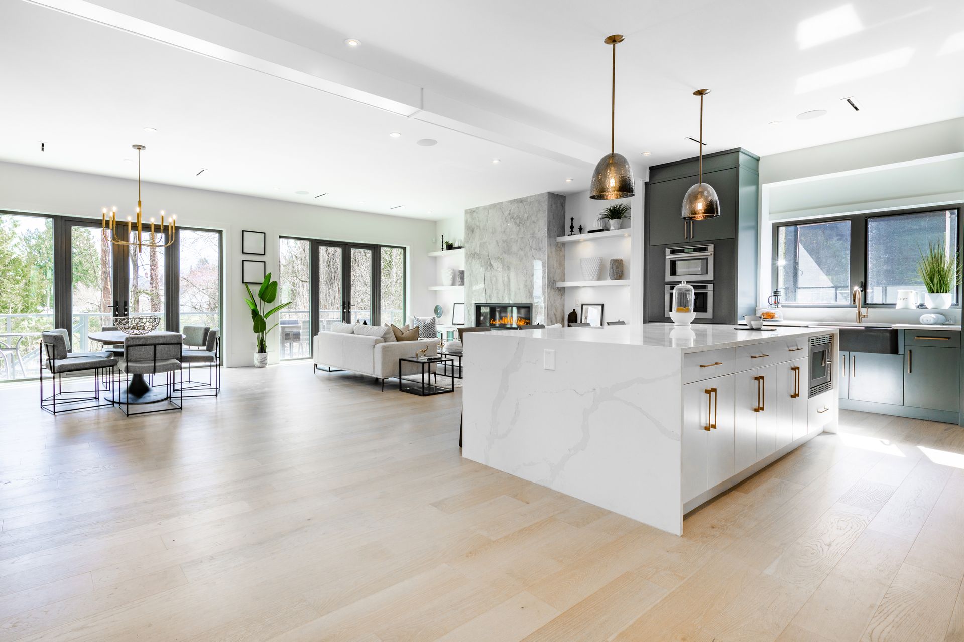 Spacious, modern kitchen with large island, open to dining and living areas with hardwood floors and lots of natural light.