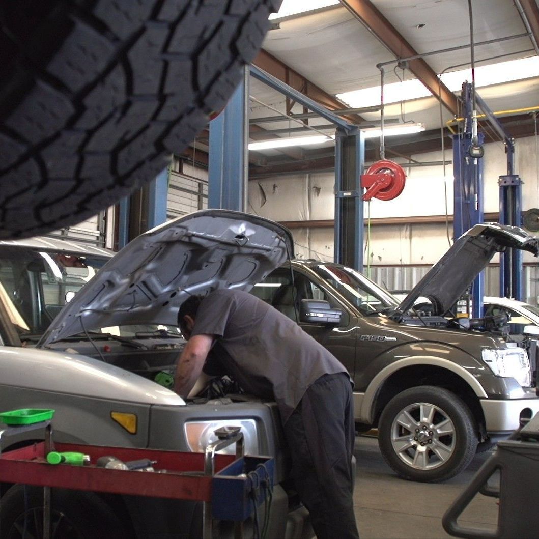 A man is working on a truck in a garage.