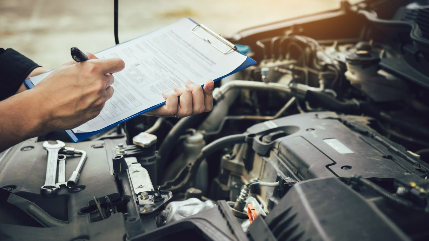 Silver Ford F-150 truck raised on a lift in a repair shop for maintenance.
