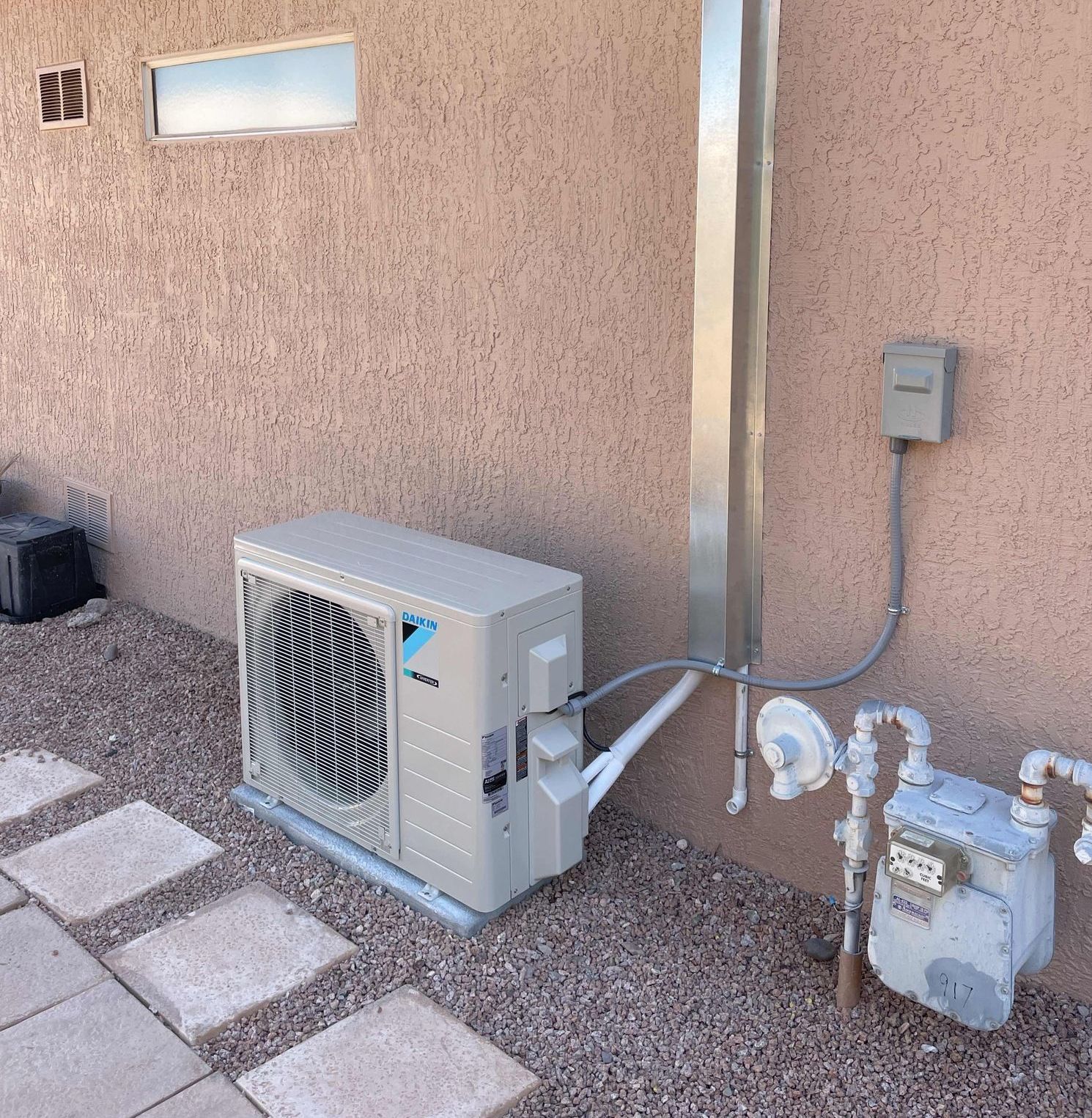 An air conditioner is attached to the side of a building