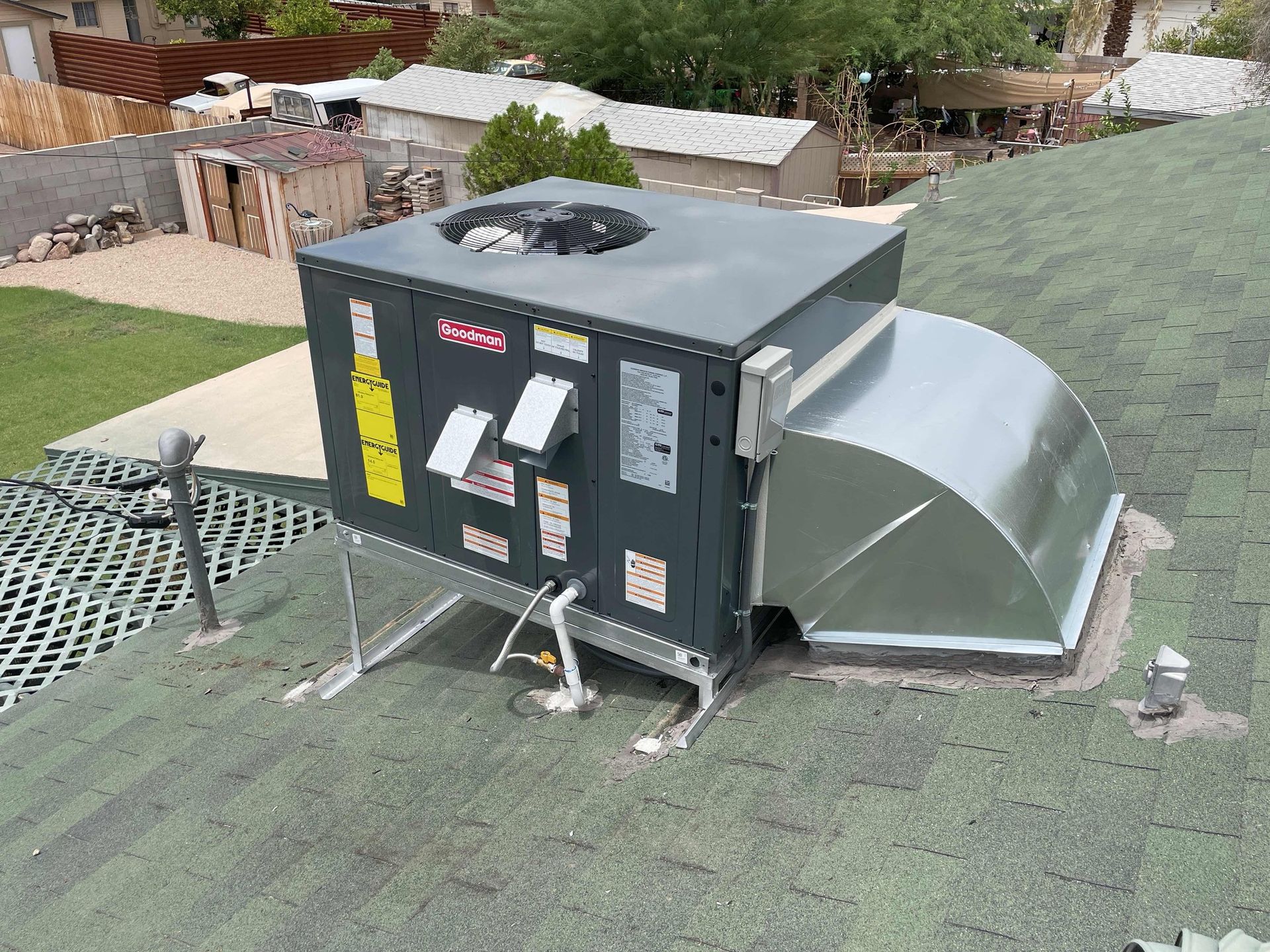 An air conditioner is sitting on top of a green roof.