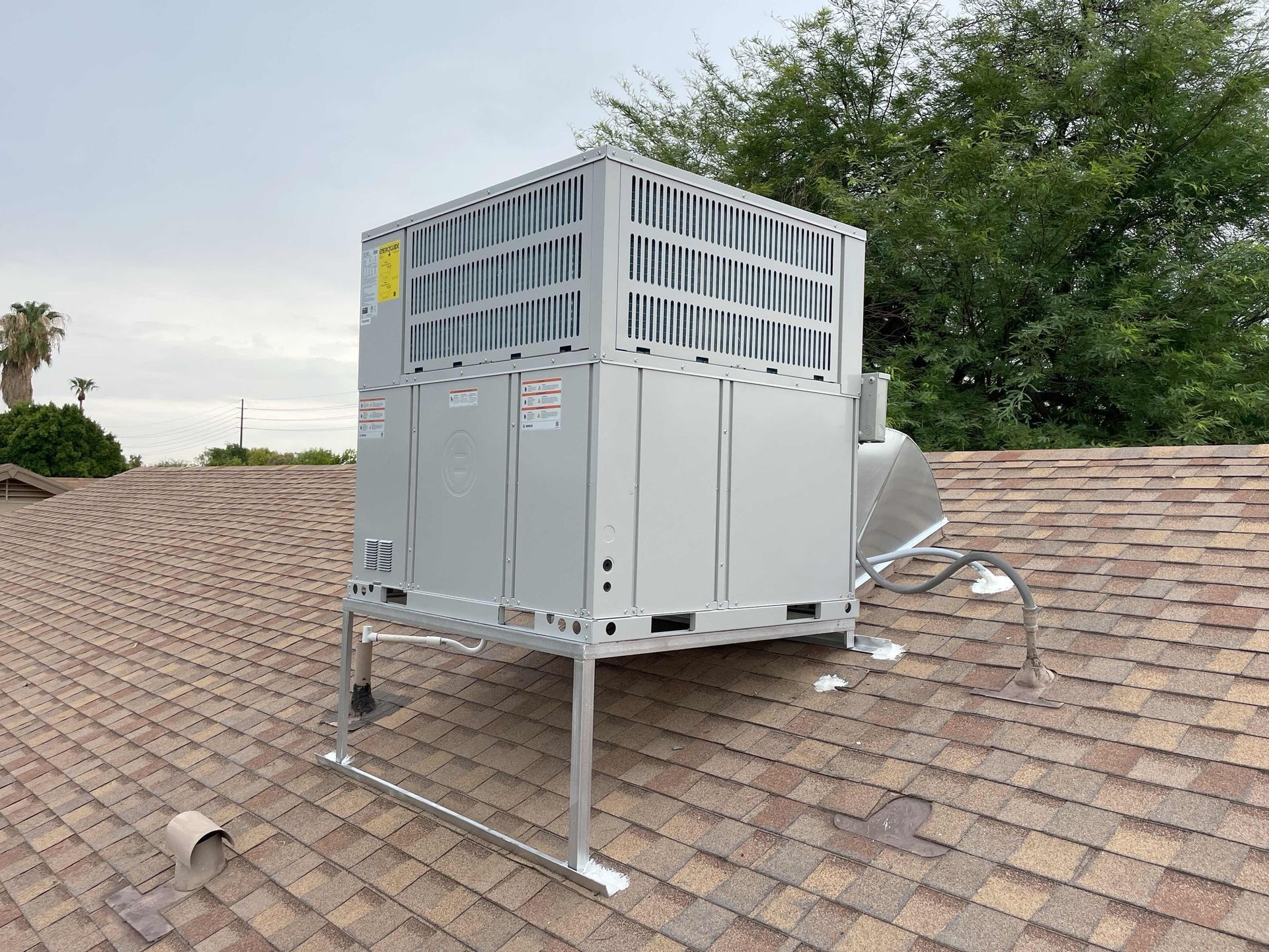 A large air conditioner is sitting on top of a roof.