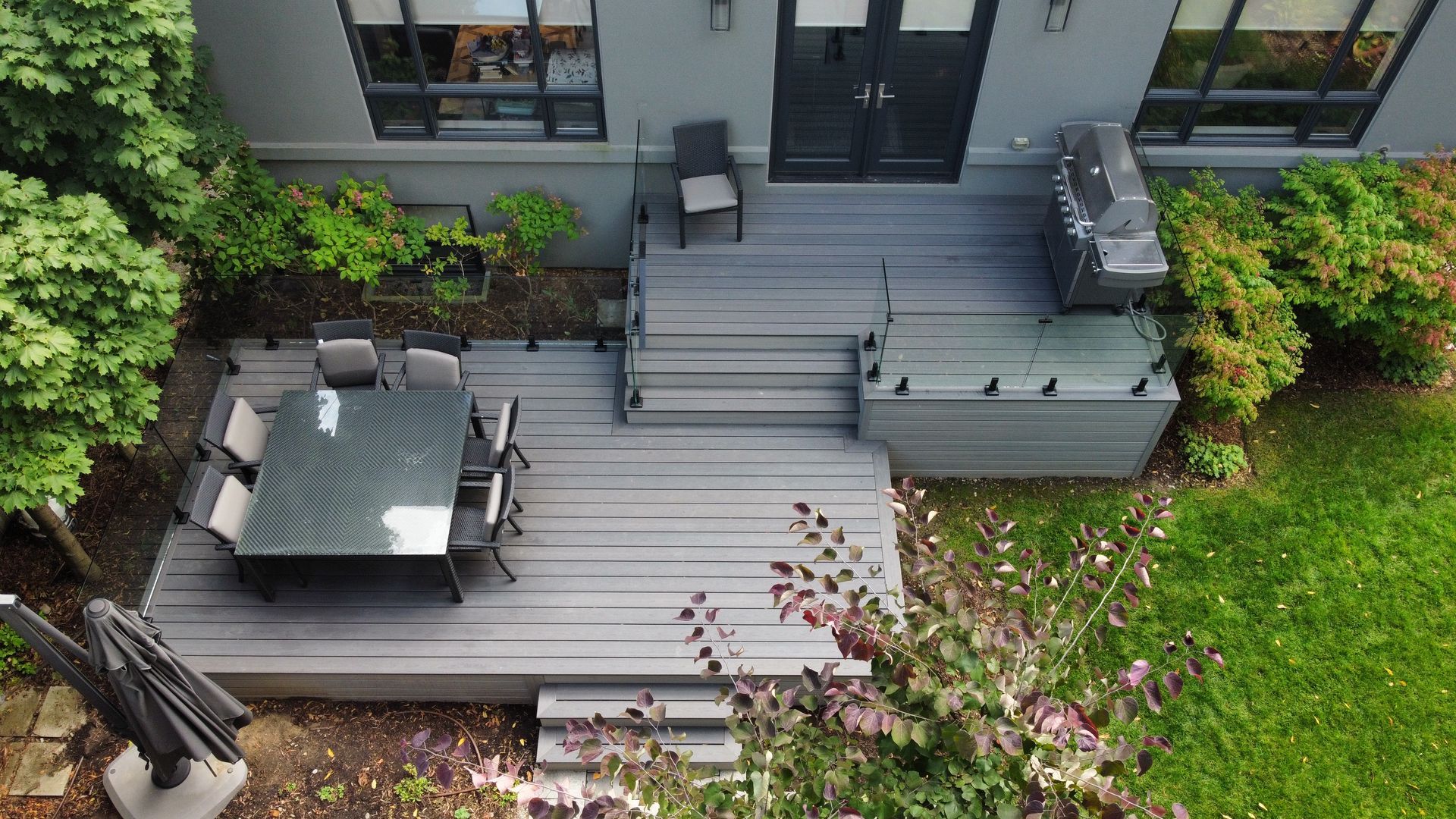 An aerial view of a patio with a table and chairs and a grill.