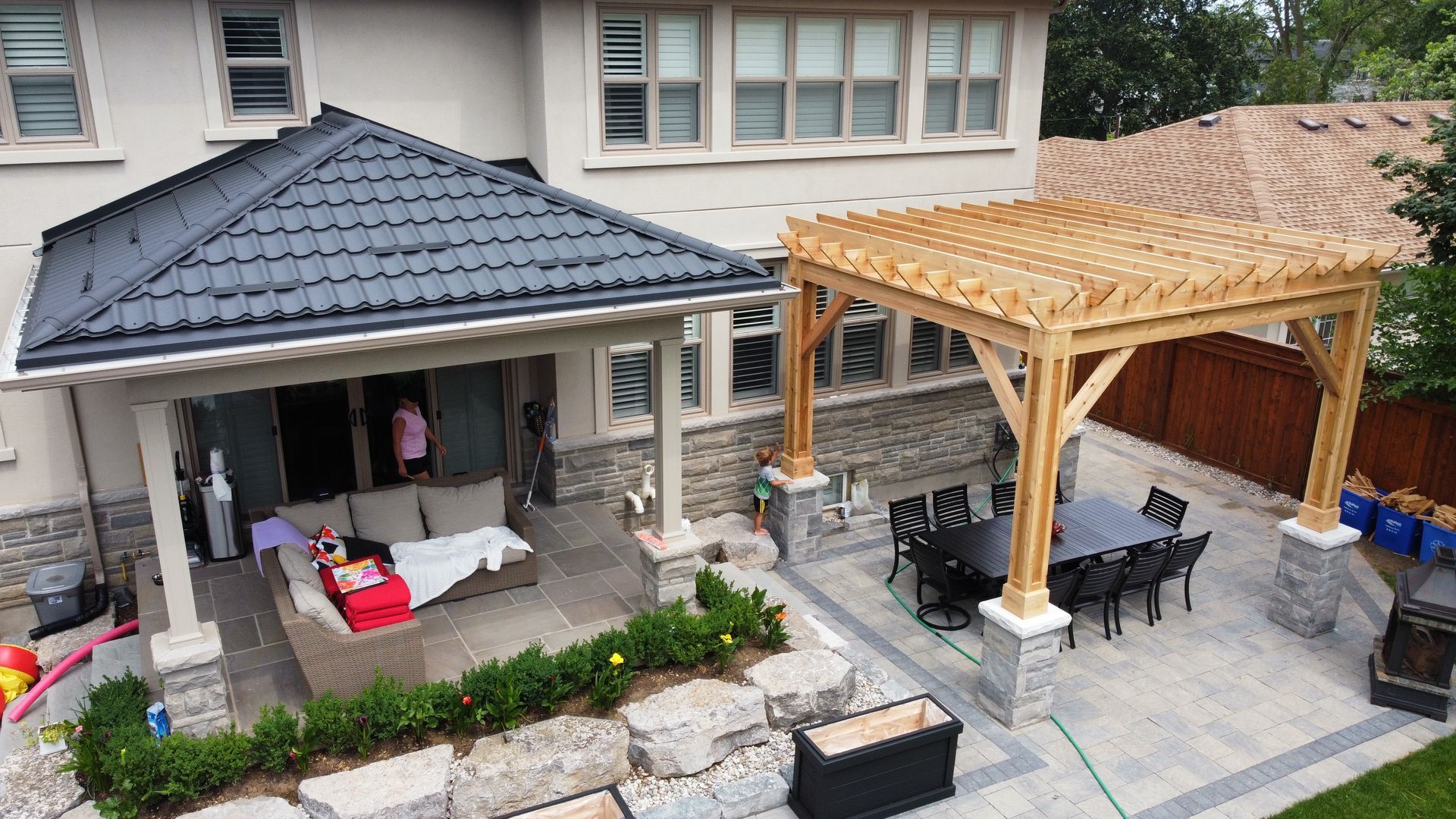 Backyard patio with a covered seating area and a pergola over a dining set.