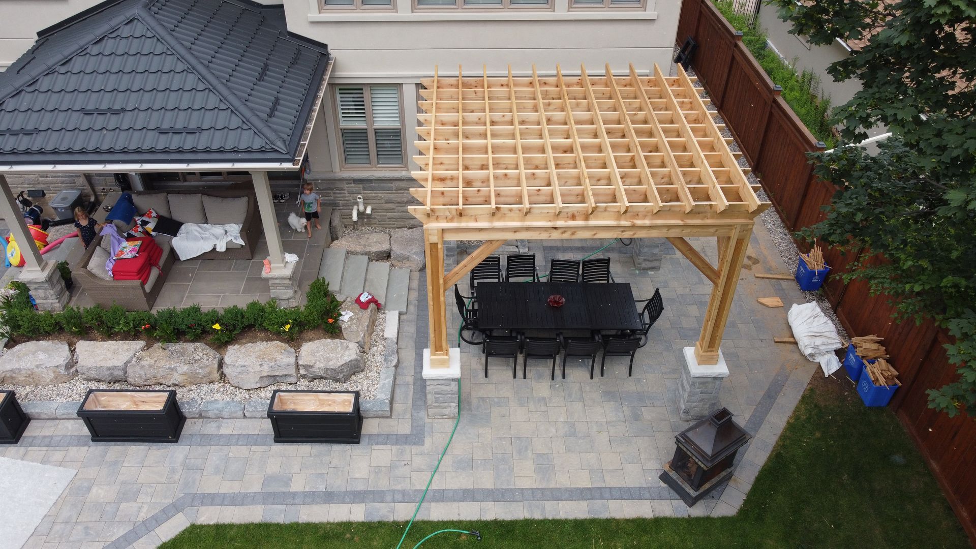 An aerial view of a backyard with a pergola and a table and chairs.