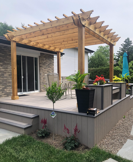 A wooden pergola is sitting on top of a patio next to a house.