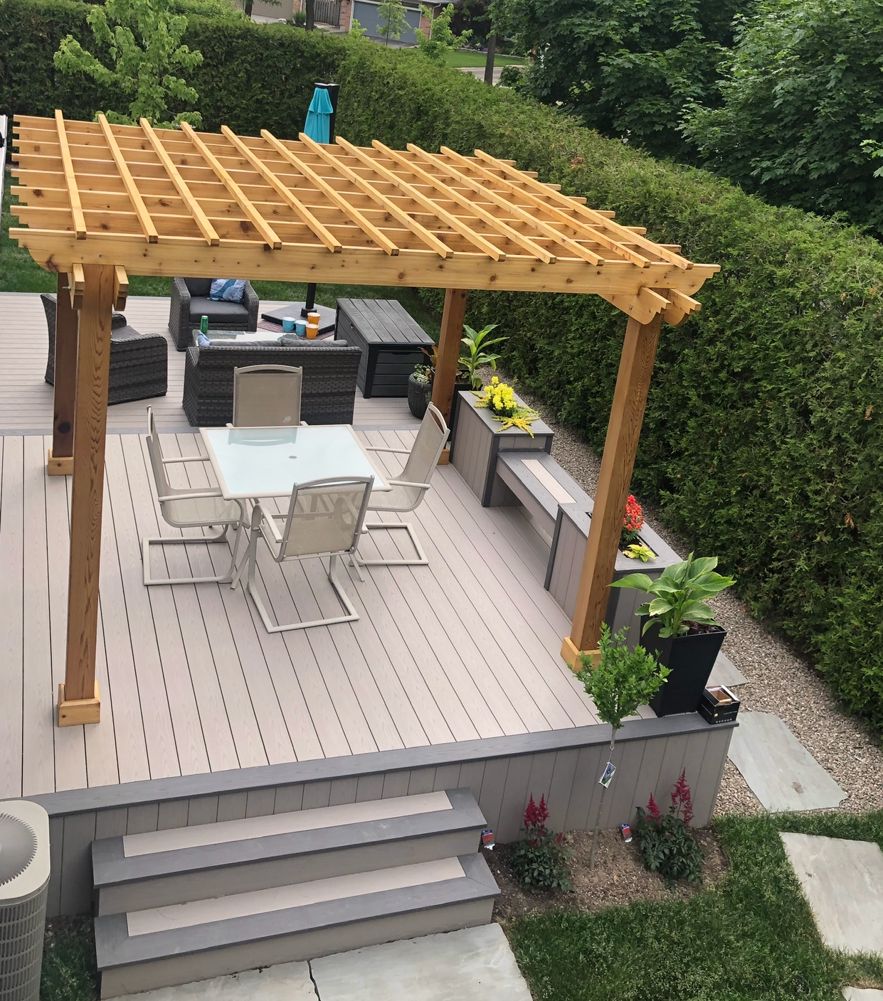 A deck with a table and chairs under a pergola