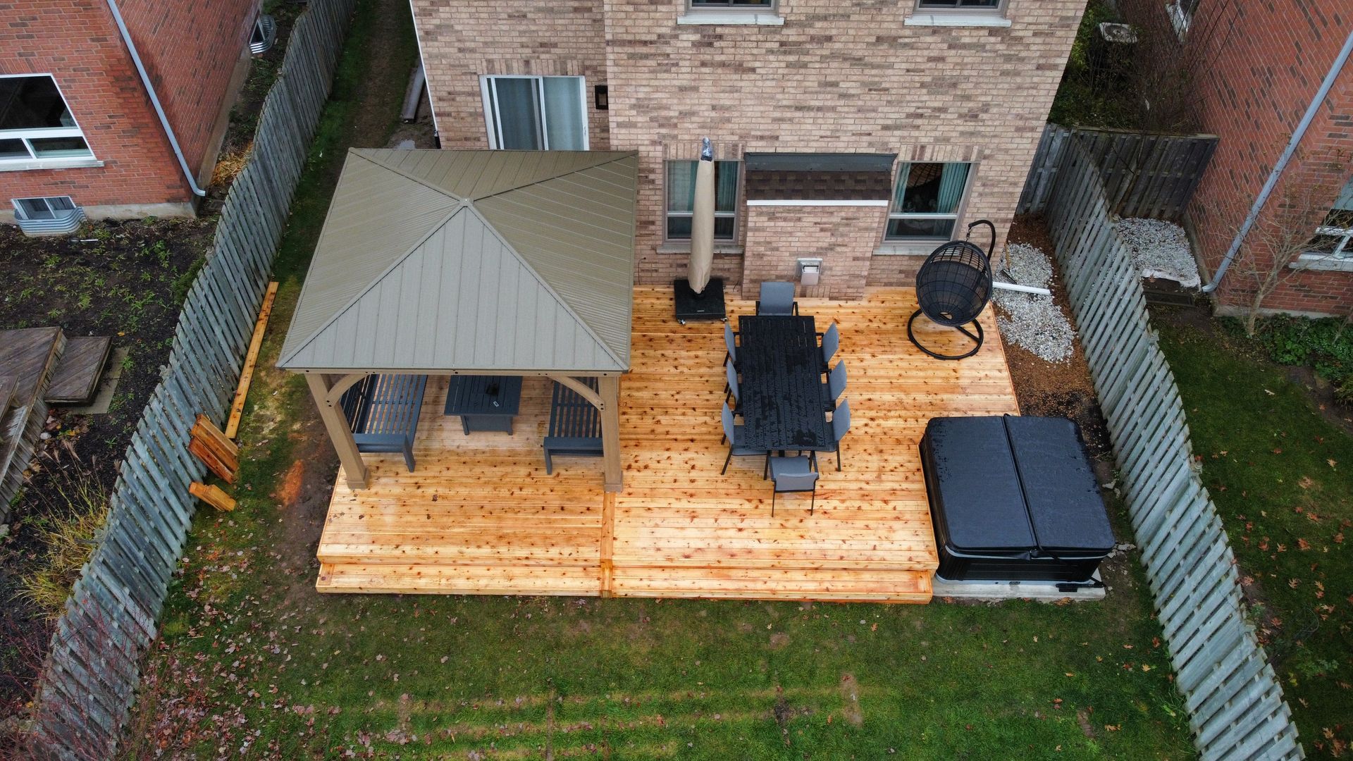 An aerial view of a wooden deck with a gazebo and a hot tub.