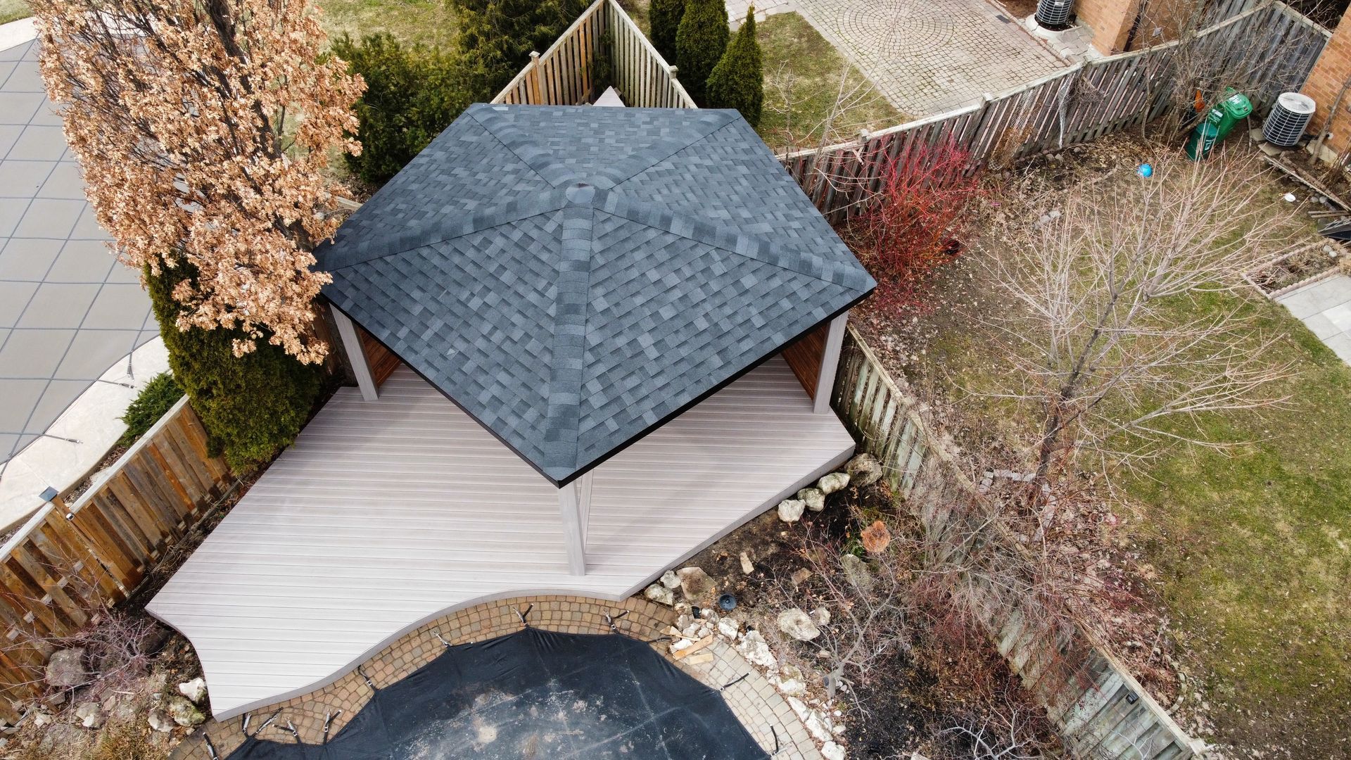 An aerial view of a backyard with a deck and a pool.