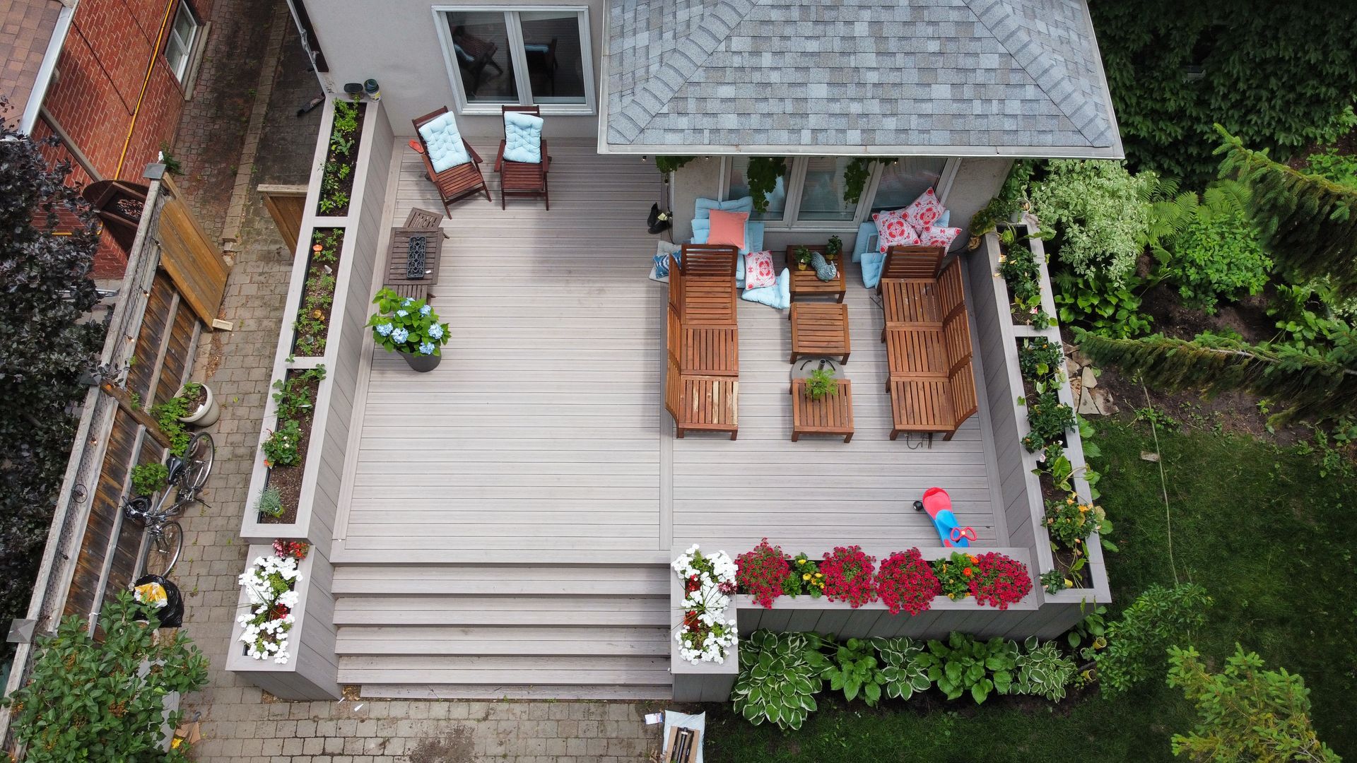An aerial view of a deck with furniture and a house in the background.